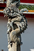 Bangkok Wat Arun - Detail of stone pillars with entwined dragons at the second entrace gate of the ubosot.  